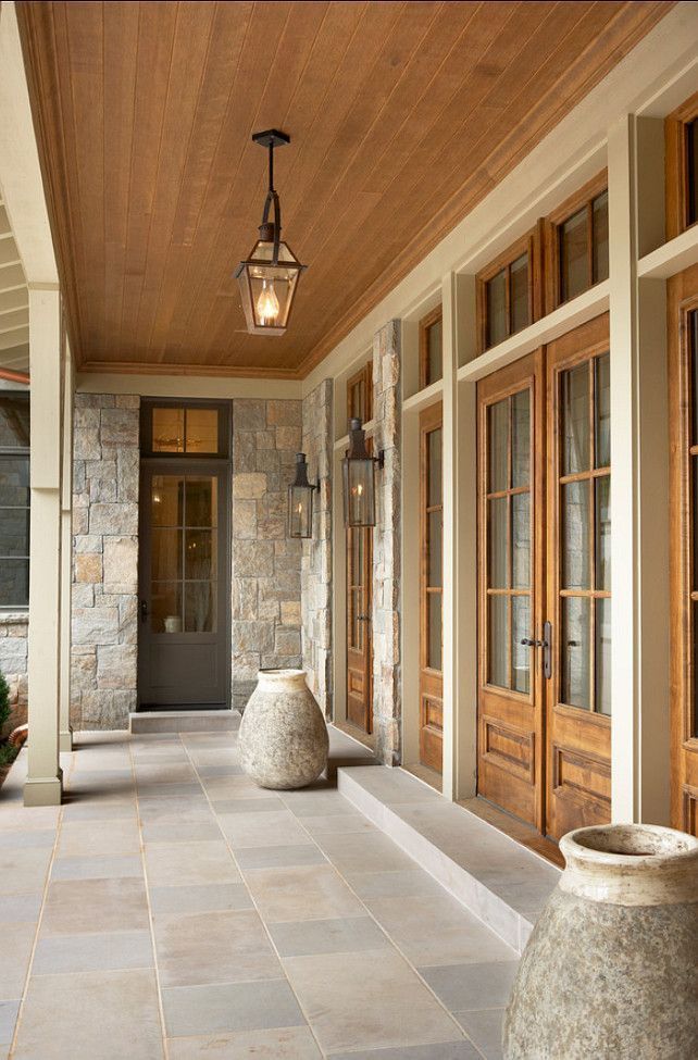 Beautiful covered porch with wood ceiling and stone flooring.