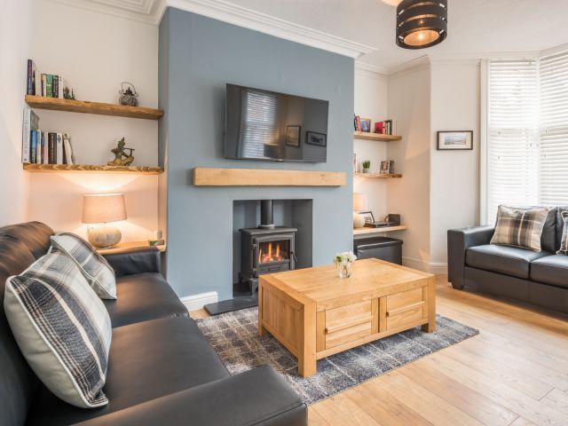 With an elegant colour palette and a log burner, the sitting room at Cartref Cot...