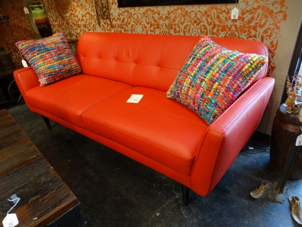 This bright red leather sofa features tufts and two seat section
