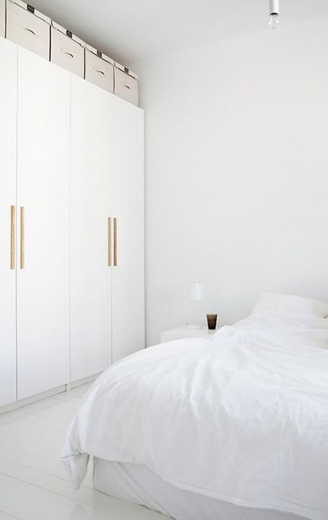 white wardrobe with wooden handles | images by Mikko Ryhänen .